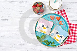 Penguin toasts with coloured spread on a plate, food for kids idea