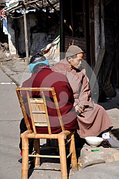 Pengzhou, China: Monk & Woman Sitting in Front of Home