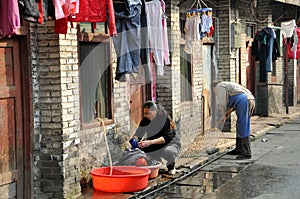 Pengzhou, China: Woman Doing Laundry on Old Street