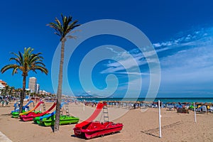 Peniscola beach Spain with colourful pedalos in summer tourist destination