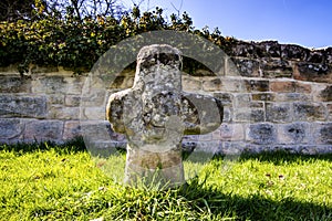 Penitence cross with old medieval abbey wall photo