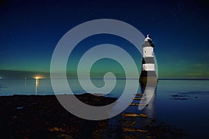 Penmon point light house in Anglesey island with Northern Lights on the horizon