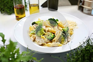 Penne with chicken, broccoli, onion, cream and cheese. Mediterranean cuisine. Dinner in a restaurant.