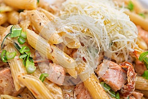 Penne pasta bolognese with parmesan, served on white plate