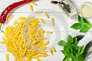 Penne Pasta, green basil, parmesan, sesame, garlic, chilli, eggs lie on a white tree table