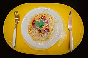 Penne pasta in tomato sauce with chicken, tomatoes decorated with parsley on a wooden table.