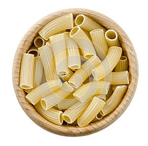 Penne rigate pasta in wooden bowl. Uncooked dried durum wheat semolina