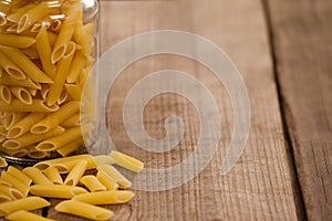 Pennette pasta spilled out of glass jar