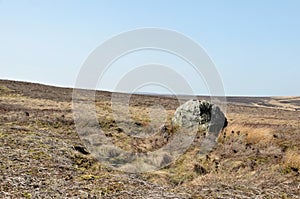 Pennine landscape with large old boulder or standing stone on midgley moor in west yorkshire