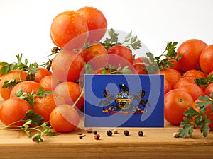 Pennsylvania flag on a wooden panel with tomatoes isolated on a