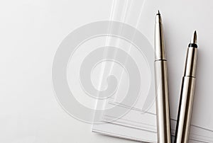 Pens and Blank Papers on Top of White Table