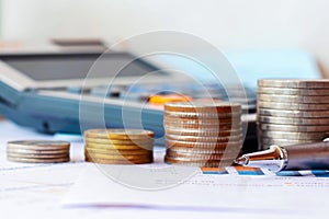 Pens, coins, and calculators placed on financial reports.