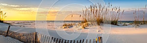 Panoramic photo of a beautiful sunrise at Pensacola Beach Florida with sea oats dunes, and a board fence photo