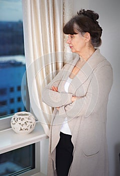 Pension age good looking woman next to window