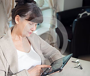 Pension age good looking woman searching in internet