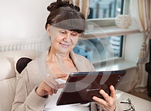 Pension age good looking woman with tablet