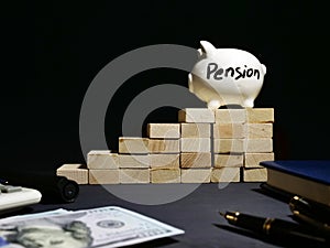 Pension written on a piggy bank on a wooden stairs. Savings for Retirement