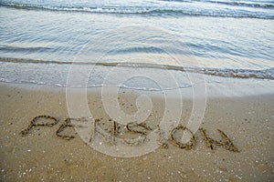 Pension written on sand by sea at beach.