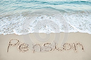 Pension written on sand by sea