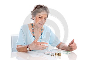 Pensioner counts her income - elder woman isolated on white back