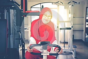 Pensioner female doing exercise with static bicycle