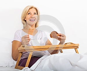 Pensioner having breakfast in bed