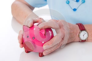 Pensioner holding her piggy bank