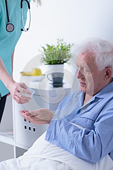 Pensioner lying in hospital bed