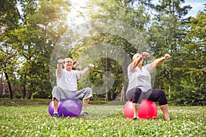 Pensioner man and woman doing fitness exercises on fitness ball