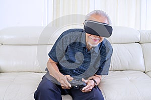 Pensioner playing game with virtual reality glasses