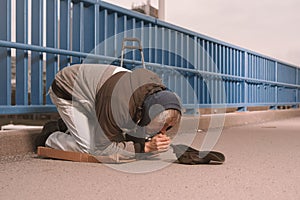 Pensioner in poor style of beggar asking on public for some pittance