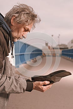 Pensioner in poor style of beggar asking on public for some pittance