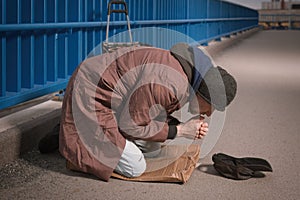 Pensioner in poor style of beggar asking on public for some pittance