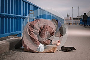 Pensioner in poor style of beggar asking on public for some pittance