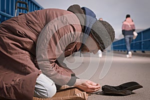 Pensioner in poor style of beggar asking on public for some pittance