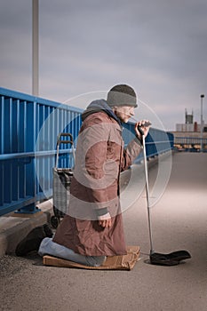 Pensioner in poor style of beggar asking on public for some pittance