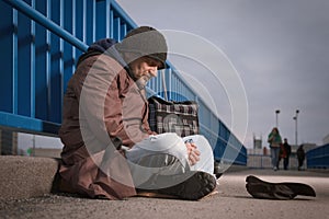 Pensioner in poor style of beggar asking on public for some pittance