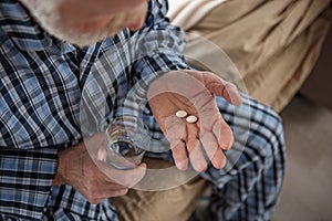Pensioner taking medicine at home