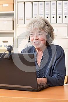 Pensioner telephoning via skype photo