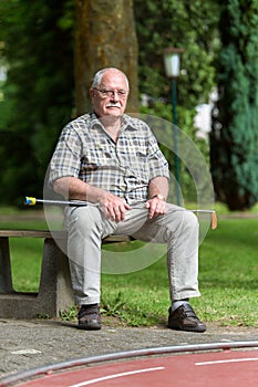 A pensioner is waiting for his shot at a minigolf court at a sun