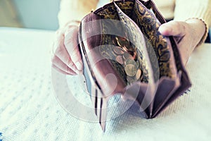 Pensioner woman holding in hands wallet with euro coins