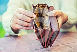 Pensioner woman holding hands wallet without money