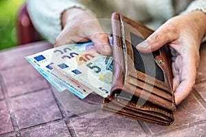 Pensioner woman holding in hands wallet without money photo