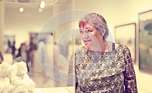 Pensioner woman watching at sculpture