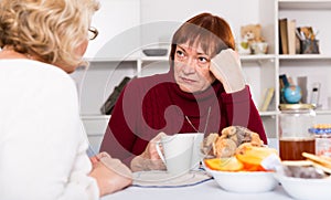 Pensioners females quarreling at kitchen