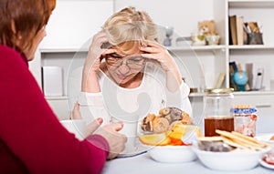 Pensioners females quarreling at kitchen
