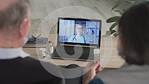 pensioners man and woman are concerned about their health and talk to doctor via video call on laptop while sitting at