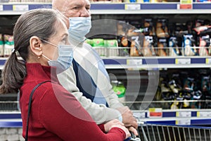Pensioners in protective masks choosing products  in  supermarket