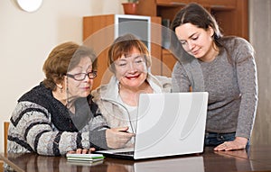 Pensioners and relative with laptop