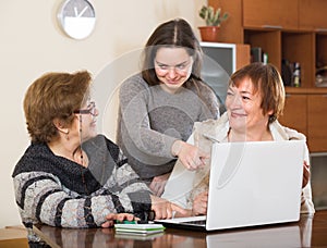 Pensioners and relative with laptop